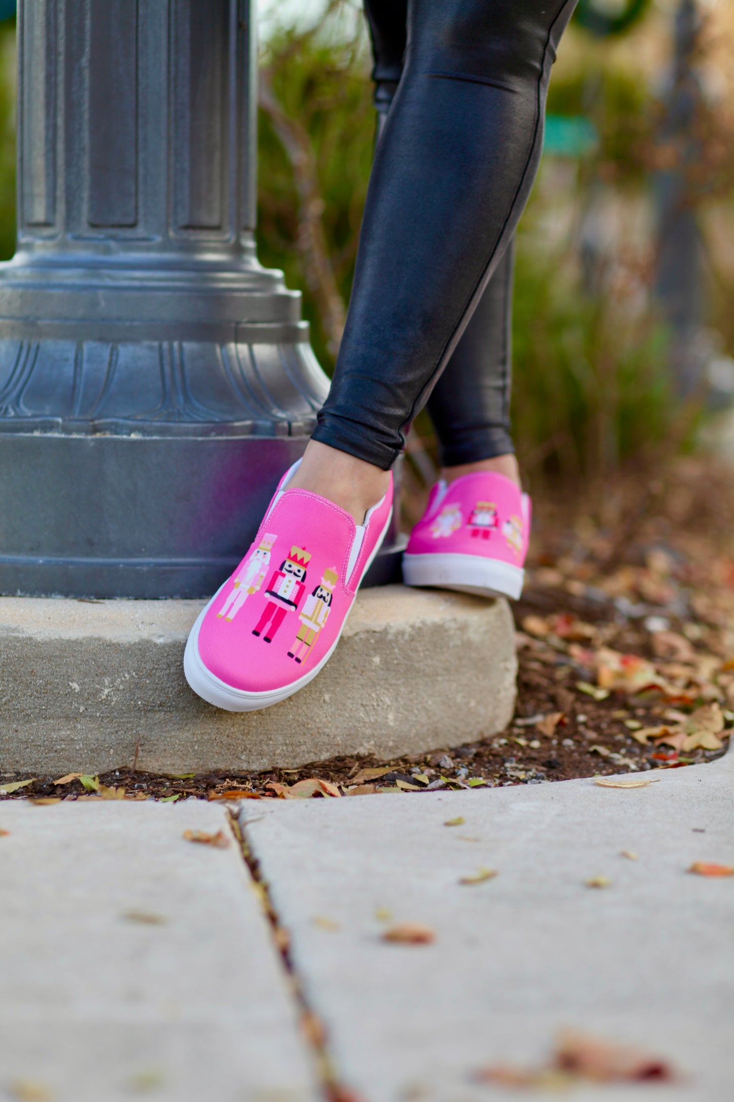 Person wearing pink Christmas Stylin Brunette slip-on sneakers with three pink nutcrackers